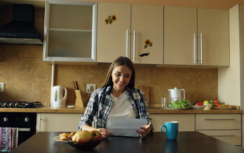 Mujer revisando un documento en la mesa de su cocina