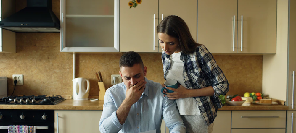 Pareja preocupada revisando una cuenta en la cocina de su casa