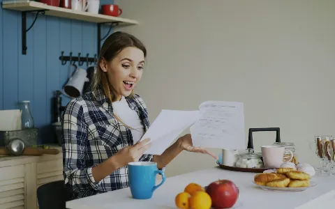 Mujer revisando documentos en la mesa de su casa