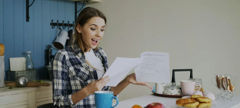 Mujer revisando documentos en la mesa de su casa